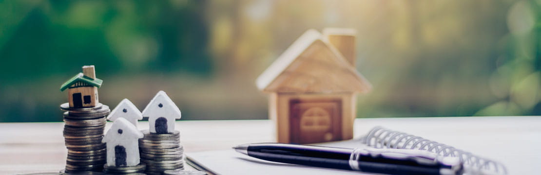 House model with money coins and notebook.House buying planning ideas